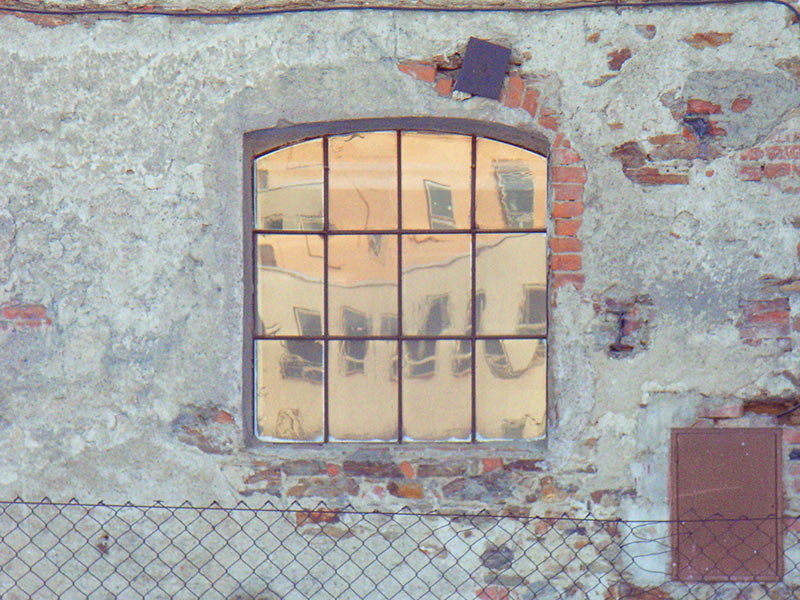 Odbicie w szybach starego domu który wydaje się złoty