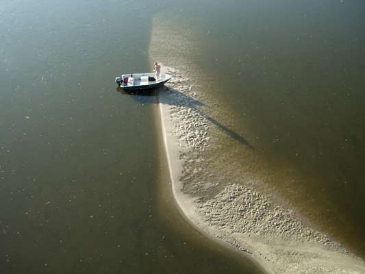 rzeka Wisła i łacha na rzece z przycumowana łódką